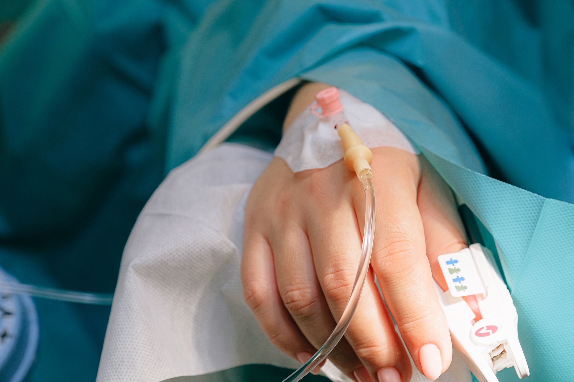An IV line being administered in a clinical setting